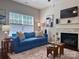 Bright living room with a large window, a comfortable blue sofa, and a marble fireplace at 16121 Wrights Ferry Rd, Charlotte, NC 28278