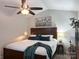 Comfortable main bedroom with a dark wood bed frame, a painting, and plants at 16121 Wrights Ferry Rd, Charlotte, NC 28278