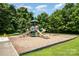 Community playground featuring multiple slides, swings, and play structures nestled among mature trees and green space at 16121 Wrights Ferry Rd, Charlotte, NC 28278