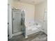 Well-lit bathroom featuring a glass-enclosed shower and a luxurious soaking tub at 1647 Backcreek Ln, Gastonia, NC 28054