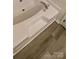 Relaxing bathtub with modern fixtures and light wood-look flooring for a spa-like experience at 1647 Backcreek Ln, Gastonia, NC 28054