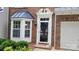 Close-up of an elegantly framed front door with detailed trim and sidelights, set in a brick facade at 1647 Backcreek Ln, Gastonia, NC 28054