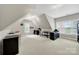 Finished attic featuring multiple skylights, a variety of office furniture, and soft neutral carpet at 16714 Hammock Creek Pl, Charlotte, NC 28278