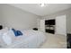 Bright bedroom featuring plush carpet, blue pillows on the bed, and a large TV on a dark console at 16714 Hammock Creek Pl, Charlotte, NC 28278