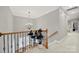 A beautiful chandelier hangs over the staircase in this spacious hallway at 16714 Hammock Creek Pl, Charlotte, NC 28278