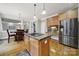 Bright kitchen featuring a central island with cooktop, stainless steel appliances, and hardwood floors at 16714 Hammock Creek Pl, Charlotte, NC 28278
