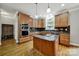 Spacious kitchen with wood cabinets, granite countertops, stainless steel appliances, and a kitchen island at 16714 Hammock Creek Pl, Charlotte, NC 28278