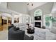 Open living room with fireplace, tall windows, comfortable seating, and a view into the kitchen at 16714 Hammock Creek Pl, Charlotte, NC 28278