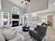 Bright living room with fireplace, ceiling fan, tall windows, and comfortable seating at 16714 Hammock Creek Pl, Charlotte, NC 28278