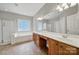 Bright bathroom features double sinks, a shower, and a large soaking tub at 16714 Hammock Creek Pl, Charlotte, NC 28278