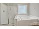 Bright bathroom featuring a walk-in shower and a soaking tub for your relaxation at 16714 Hammock Creek Pl, Charlotte, NC 28278