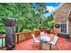 Relaxing back patio with a red deck, a glass table with chairs, and mature trees providing privacy at 16714 Hammock Creek Pl, Charlotte, NC 28278