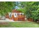 Backyard with a wooden deck, pergola, brick patio, and white door at 1734 Seifert Cir, Charlotte, NC 28205