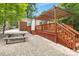 Inviting backyard with a wooden deck, pergola, brick patio, picnic table, and beautiful landscaping at 1734 Seifert Cir, Charlotte, NC 28205