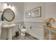 Stylish half bath with pedestal sink, decorative mirror, and charming coastal-inspired decor at 18013 Grey Mossrun Dr, Charlotte, NC 28278