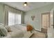 This bedroom offers soothing light-green paint and natural light through large windows with custom ceiling fan and fixtures at 18013 Grey Mossrun Dr, Charlotte, NC 28278