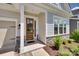 Close up of the front of the home showcasing stone accents, the front door, and mature landscaping at 18013 Grey Mossrun Dr, Charlotte, NC 28278