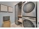 This laundry room features custom cabinets, modern gray stacked washer and dryer, and uniquely patterned floor tiles at 18013 Grey Mossrun Dr, Charlotte, NC 28278