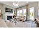 Cozy living room with fireplace, large windows, stylish curtains, and access to outdoor patio at 18013 Grey Mossrun Dr, Charlotte, NC 28278
