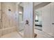 This is a large glass shower with tile surround, shower bench, and both standard and rain shower heads at 18013 Grey Mossrun Dr, Charlotte, NC 28278
