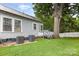 Spacious backyard featuring a lush lawn, a charming shade tree with a swing, and the home's exterior at 215 S Shaver St, Salisbury, NC 28144