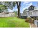 A backyard featuring a deck and a large tree, partially surrounded by a white picket fence at 215 S Shaver St, Salisbury, NC 28144