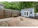 Backyard featuring a modern shed, pea gravel, brick pavers, and a wood fence, creating a versatile outdoor space at 215 S Shaver St, Salisbury, NC 28144