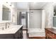 Bright bathroom featuring a tiled shower, vanity, and wood-look flooring, combining modern and traditional elements at 215 S Shaver St, Salisbury, NC 28144