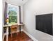 A bedroom area featuring hardwood floors, a built-in desk, and a chalkboard for creative expression at 215 S Shaver St, Salisbury, NC 28144
