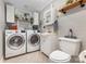 Well-lit laundry room featuring modern washer and dryer, sink, and storage, creating a functional space at 215 S Shaver St, Salisbury, NC 28144