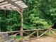 View of backyard deck with swing, overlooking lush green trees, offering outdoor relaxation at 2222 Raven Dr, Rock Hill, SC 29732
