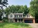 Charming two-story home with a lush green lawn and mature trees enhancing its curb appeal at 2222 Raven Dr, Rock Hill, SC 29732
