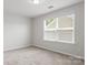 Bright and airy bedroom with plush carpeting and a large window with blinds at 2236 Prairie Rd, Concord, NC 28027