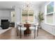 The bright dining area features a round wooden table with modern light fixture and view of the backyard at 2236 Prairie Rd, Concord, NC 28027