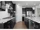 Chic kitchen showcasing black cabinets, granite counters, stainless steel appliances, and wood flooring at 2236 Prairie Rd, Concord, NC 28027