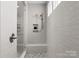 Bright, modern shower featuring a glass door, a built-in shelf, and tiled walls at 2236 Prairie Rd, Concord, NC 28027