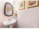 Stylish powder room features a modern pedestal sink, decorative mirror, and art prints adorning the pastel-colored walls at 2313 Blueberry St, Belmont, NC 28012