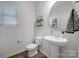 Charming powder room with pedestal sink, round mirror and modern fixtures at 240 Briana Marie Way, Indian Trail, NC 28079