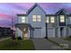 Charming townhome with neutral siding, attached garage, and well-manicured lawn at dusk at 240 Briana Marie Way, Indian Trail, NC 28079