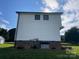 Back exterior of the home with white siding, a brick foundation, and a lush green lawn at 2412 Elizabeth Ave, Staley, NC 28150