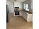 Bright kitchen featuring white cabinets, stainless steel appliances, and laminate flooring at 2412 Elizabeth Ave, Staley, NC 28150