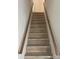 Staircase featuring laminate treads, white risers, and matching handrails at 2412 Elizabeth Ave, Staley, NC 28150