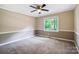 Carpeted bedroom featuring two-tone paint, ceiling fan and a large window at 2434 Olewoods Ct, Rock Hill, SC 29732