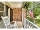 Inviting front porch with a rocking chair, brick details, and an American flag at 2434 Olewoods Ct, Rock Hill, SC 29732