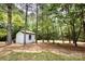 Backyard storage shed nestled among mature trees and a hanging hammock at 2434 Olewoods Ct, Rock Hill, SC 29732