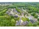 A high aerial view of a residential neighborhood nestled among many green trees and manicured lawns at 2563 Firethorn Ct, Gastonia, NC 28056