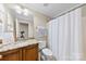 Traditional bathroom with granite countertop, white toilet and shower with curtain at 2563 Firethorn Ct, Gastonia, NC 28056