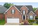 Charming two-story brick home with well-manicured lawn, a two-car garage, and landscaped front yard at 2563 Firethorn Ct, Gastonia, NC 28056