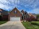 Two-story brick home with attached two car garage, beautiful landscaping, and driveway at 2563 Firethorn Ct, Gastonia, NC 28056