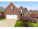 Charming two-story brick home with well-manicured lawn, a two-car garage, and landscaped front yard at 2563 Firethorn Ct, Gastonia, NC 28056